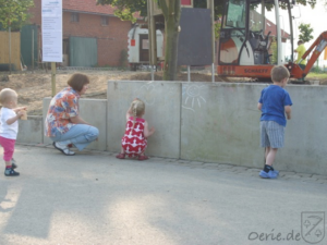DIe Kinder überbrücken die Wartezeit und bemalen die Betonmauer